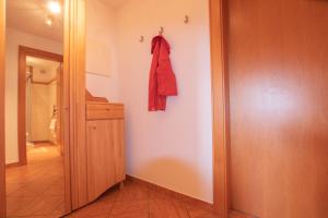 korytarz z czerwonym płaszczem wiszącym na ścianie w obiekcie Ferienwohnung bis 4 Personen in Traumlage mit Kaiserblick by FeWo-Plan WILD190 w mieście Thierbach