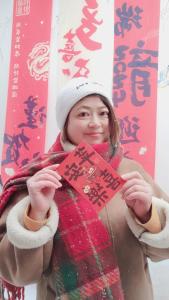 a woman holding up a sign in front of herself at Zhangjiajie Tingyutang Little Yard in Zhangjiajie