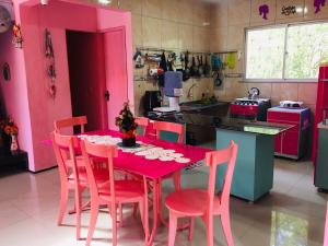 a pink kitchen with a pink table and chairs at Casa da Barbie da Serra in Pacoti