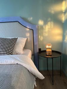 a bed with a side table with a lamp on it at Уютная и стильная квартира в центре города Караганда in Karagandy