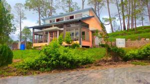 a house that is sitting on top of a field at Conifer Resort in Jajal