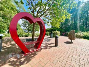 a red heart sculpture sitting on a brick sidewalk at Schlösschen am Meer in Binz +11 photos