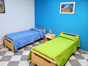 two beds in a room with blue walls at SANGIORGIO Beachfront APT in Porto San Giorgio