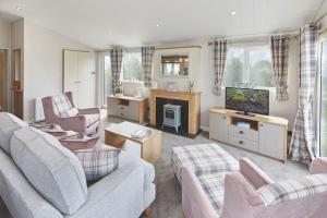 a living room with two couches and a tv at Llanrhidian Holiday Park in Llanmorlais