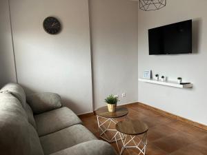 a living room with a couch and a clock on the wall at Balcón de La Iruela I in La Iruela