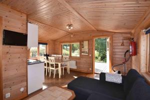 a living room with a couch and a kitchen with a table at Gangvidefarm in Stånga