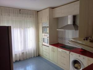 a kitchen with white cabinets and a washer and dryer at Chalet en Sieteiglesias, Sierra Norte de Madrid in Sieteiglesias