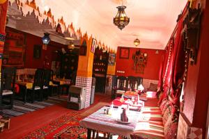 a restaurant with red walls and tables and chairs at Dar Ayour Todra Gorges in Aït Baha