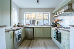 une cuisine avec un évier et une machine à laver dans l'établissement Shorethwaite, à Amble