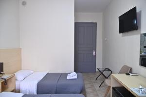 a hotel room with a bed and a couch and a door at Kentrikon in Chalkida