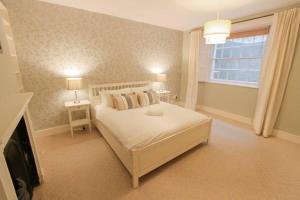 a bedroom with a white bed and a window at Large clifton one bed flat and parking in Bristol