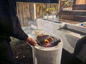 a person is cooking food on a grill at Glamour camping bedugul in Bedugul +40 photos