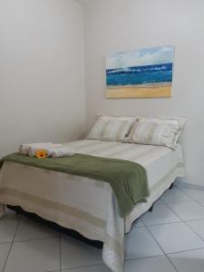 a bedroom with a bed with a painting on the wall at Pousada 4 Estações Campeche in Florianópolis +59 photos