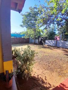 um quintal com cerca, árvores e terra em Magna Hotel 3 em Encarnación