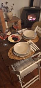 una mesa con platos de comida y copas de vino en CASA RURAL "LA CASITA" para 2 personas, en Ronda