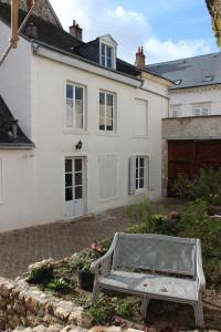 ein weißes Haus mit einer Bank davor in der Unterkunft Maison Bourgeoise classée 3 étoiles à 100 m des Bords de Loire avec parkings privés in Orléans