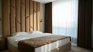 a bedroom with a bed with a large window at Hotel Tourist Lviv in Lviv +32 photos
