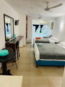 ein Schlafzimmer mit zwei Betten und einem Schreibtisch und einem Tisch in der Unterkunft Marena 3 in Playa del Carmen