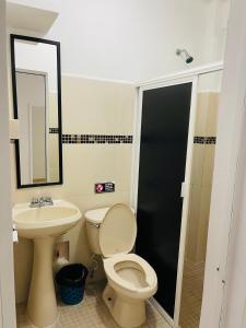 ein Badezimmer mit Toilette, Waschbecken und Spiegel in der Unterkunft Marena 3 in Playa del Carmen