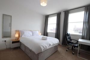 una camera da letto con un letto, una scrivania e finestre di Stylish 2 Bed in Old Market a Bristol