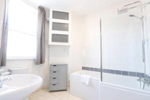 un bagno bianco con vasca e lavandino di Stylish 2 Bed in Old Market a Bristol