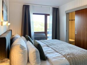 une chambre avec un lit avec des oreillers et une fenêtre dans l'établissement Schwarzwald Apartment mit Weitblick - Villa Hubertus, à Feldberg