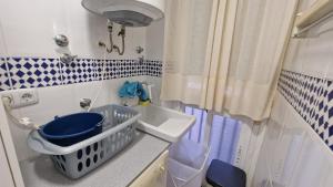 a bathroom with a sink and a basket on a counter at La Colonia Beach House in Águilas +20 photos