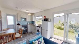 a kitchen and living room with a couch and a table at B44 Sea Urchin, Riviere Towans in Hayle