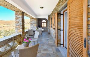 a patio with tables and chairs on a stone wall at Amazing 2 bedroom apartment overlooking the Marina of Vourkari in Vourkarion
