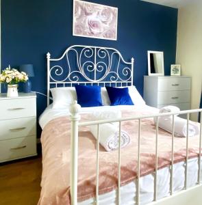 - une chambre avec un lit blanc aux murs bleus dans l'établissement Manchester Townhouse by BEVOLVE - 4 bedrooms - Free Parking, à Manchester