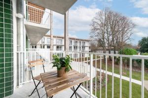 una veranda con tavolo in legno e pianta in vaso di OVELIA Saint-Saulve - Les Quatre Jardins a Saint-Saulve
