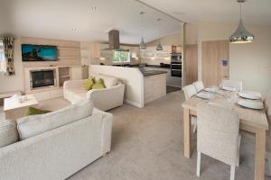 a living room with two couches and a dining room at Sandy Glade Holiday Park in Burnham on Sea