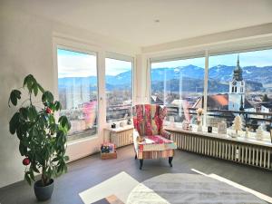 Una sala de estar con una silla y una ventana grande. en Sanosueno 5, en Sonthofen