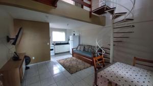 a living room with a staircase and a kitchen at Pousada 4 Estações Campeche in Florianópolis