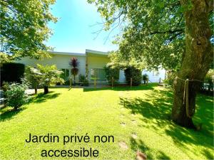 a yard with a tree and a house at Maison MAHECO in Gujan-Mestras