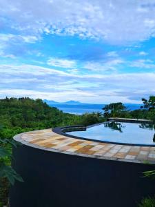a swimming pool with a view of the ocean at Kubuhill Sunset Bungalow in Nusa Penida
