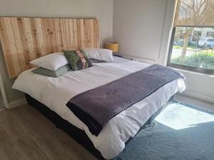 1 dormitorio con 1 cama grande con almohadas y ventana en KeMi Country House, en Caledon