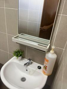a bathroom sink with a mirror and a bottle of soap at Naura Nufail Homestay Taman Aman Anak Bukit in Alor Setar