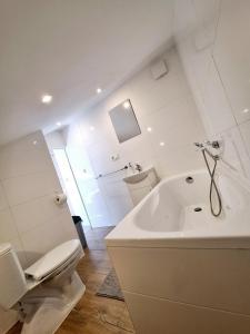 a white bathroom with a toilet and a tub at Agroturystyka KRAINA JEZIOR in Ludwin +208 photos