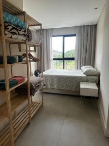 a bedroom with bunk beds and a window at Apartamento na Praia Brava, 650m do mar, ao lado de Balneário Camboriú in Itajaí