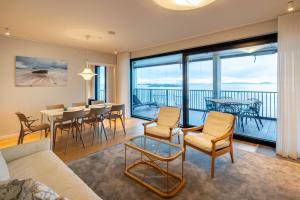 a living room with a couch and a table and chairs at Pearl Suite in Kuningatarranta Hanko in Hanko