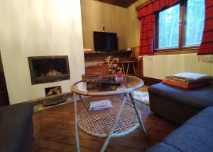 een woonkamer met een tafel en een open haard bij Chata u Lucky in Liptovský Mikuláš