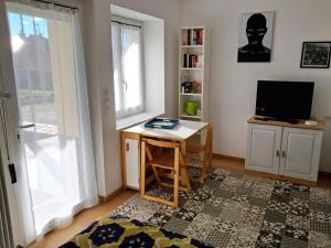 a room with a desk and a television and a window at 2 Chambres d'hôtes Chante-Coucou in Onet le Château