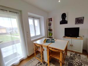 a living room with a table and a television at 2 Chambres d'hôtes Chante-Coucou in Onet le Château