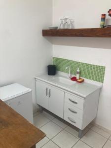 cocina con fregadero blanco y azulejos verdes en Sunset House Caraguatatuba S, en Caraguatatuba