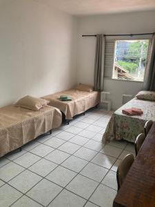 una habitación con dos camas y una ventana en Sunset House Caraguatatuba S, en Caraguatatuba