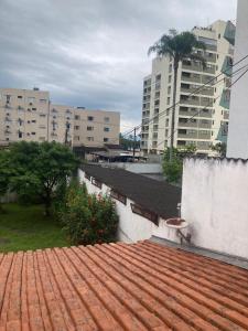 a red tile roof with buildings in the background at Sunset House Lofts Caragua in Caraguatatuba +3 photos
