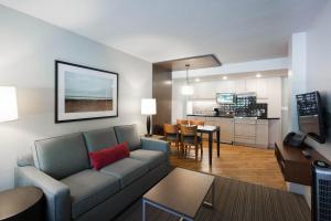 a living room with a couch and a kitchen at West Coast Suites at UBC in Vancouver