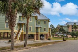 a house with a green house and palm trees at Catchin Summer by Pristine Properties in Indian Pass