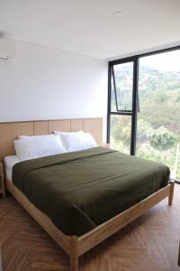 a bed in a room with a large window at Twelve Stones Dago Village in Bandung +37 photos